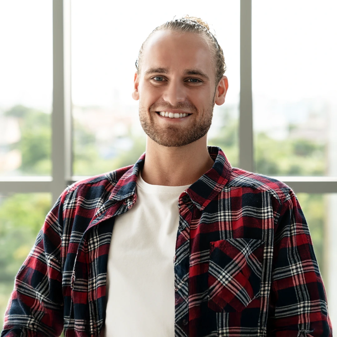 Smiling young adult in a plaid shirt at a treatment center, reflecting a welcoming, judgment-free admissions process at Changes Healing Center.