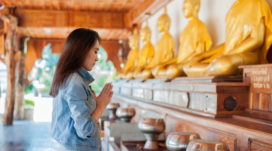 Woman kneeling saying the Buddhist prayer that talked about releasing attachment