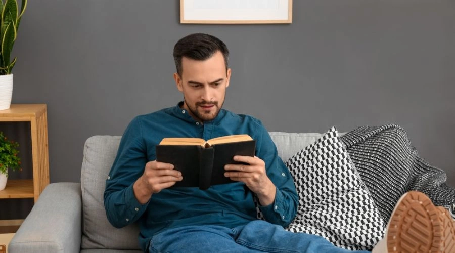 Man sitting and reading the big book and taking a personal inventory