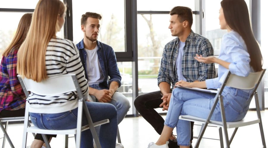 Group sitting in a circle discussing topics for an AA Meeting that make a difference