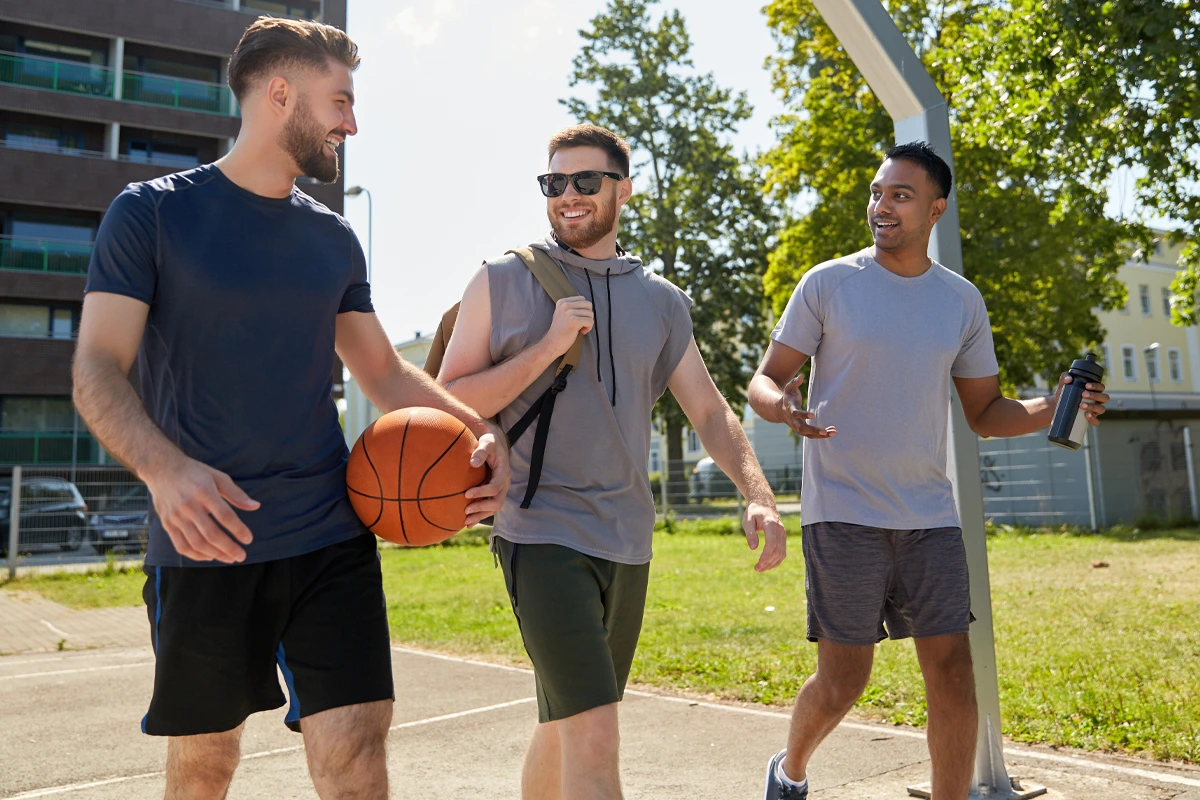 Three men enjoying basketball and conversation outdoors during recreational therapy at Changes Healing Center.
