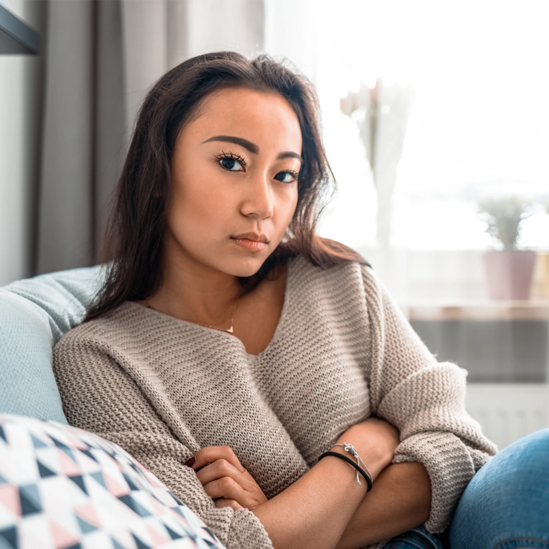 Young woman sitting thoughtfully with arms crossed, representing the challenges of ketamine addiction and the importance of seeking professional treatment.