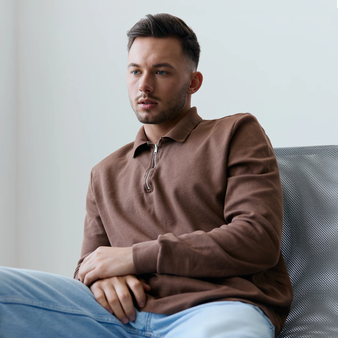 Young man sitting thoughtfully in a chair, representing the emotional challenges of ketamine addiction and the importance of professional treatment in Arizona.