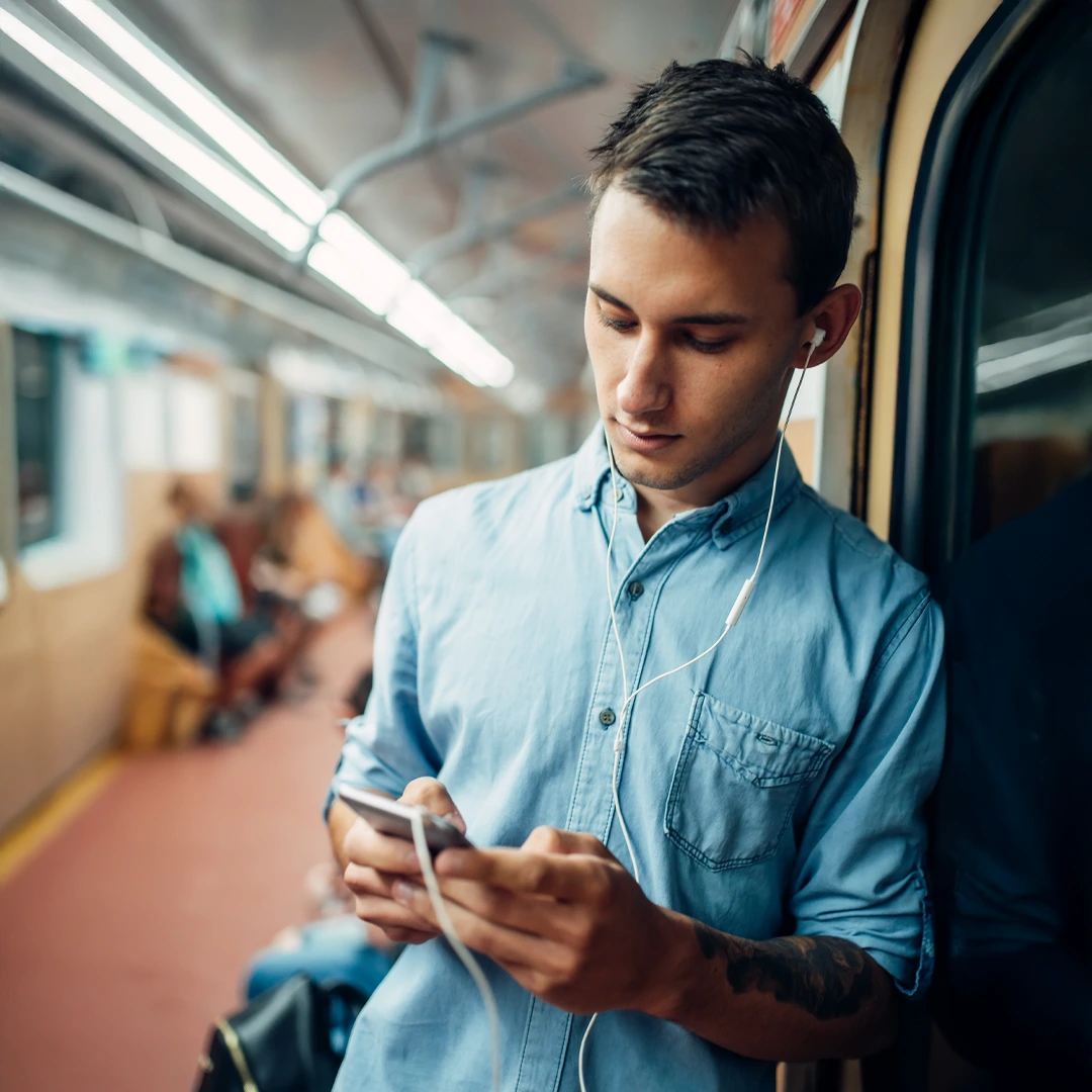 Man on public transit viewing his phone—using insurance for substance use treatment.