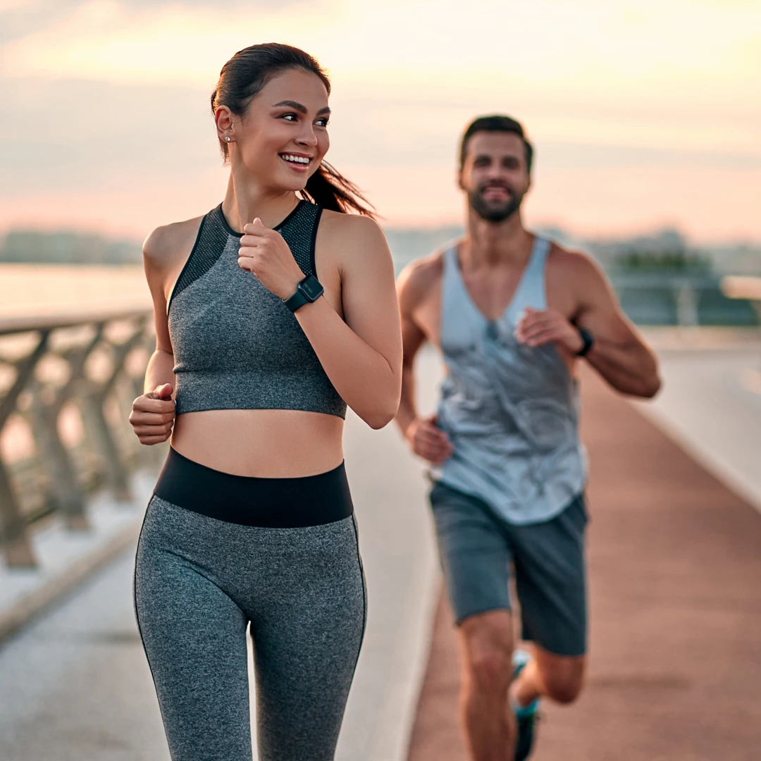 Two adults jogging at sunrise along a waterfront path—illustrating healthy recovery with Cigna in-network drug and alcohol rehab at Changes Healing Center in Arizona.