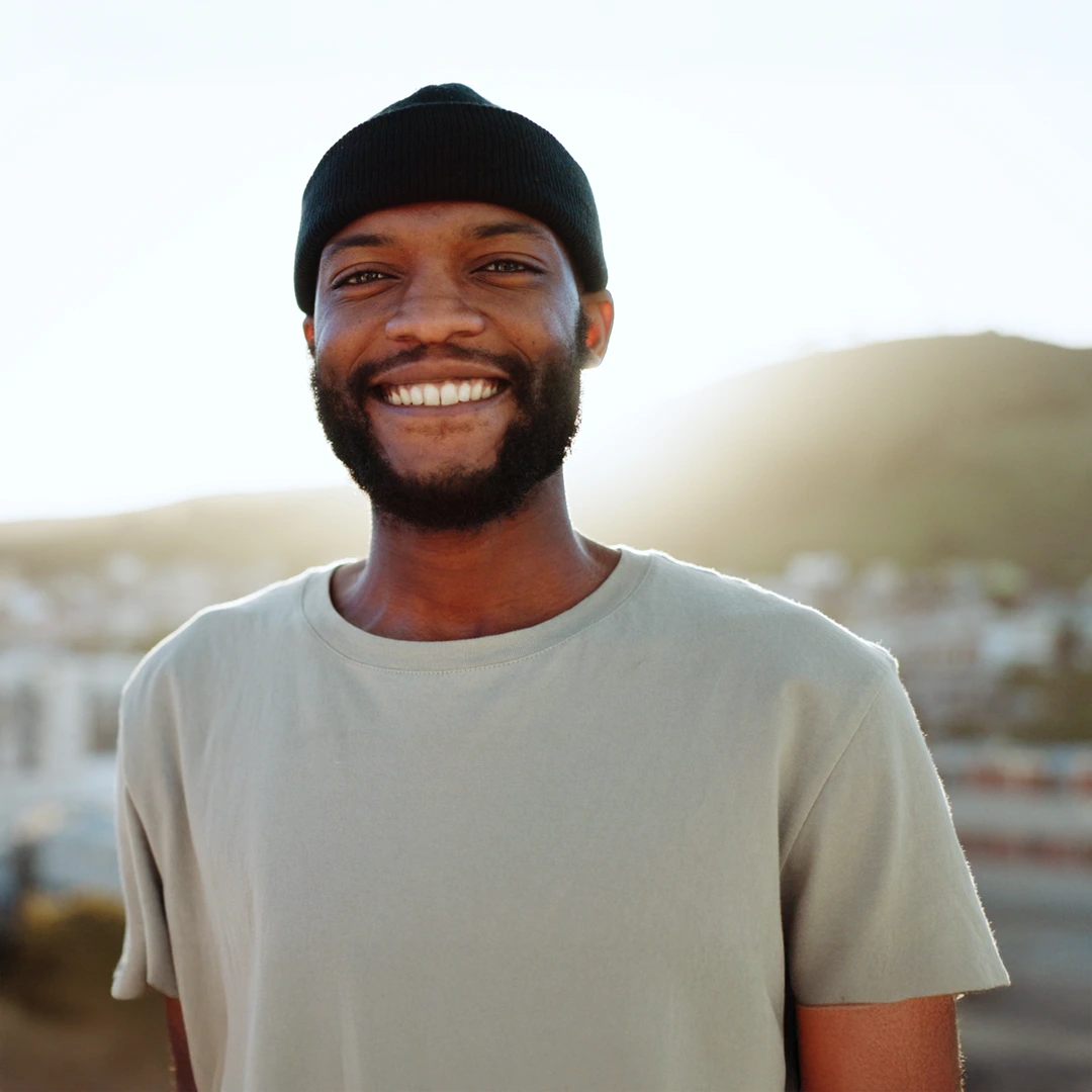 Smiling man outdoors at sunrise, symbolizing hope and stability—Cigna-covered mental and behavioral health treatment at Changes Healing Center in Arizona.
