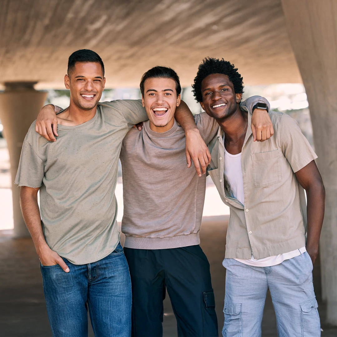 Three young men with arms around each other, illustrating peer support in Changes Healing Center’s Partial Hospitalization Program (PHP) in Arizona.