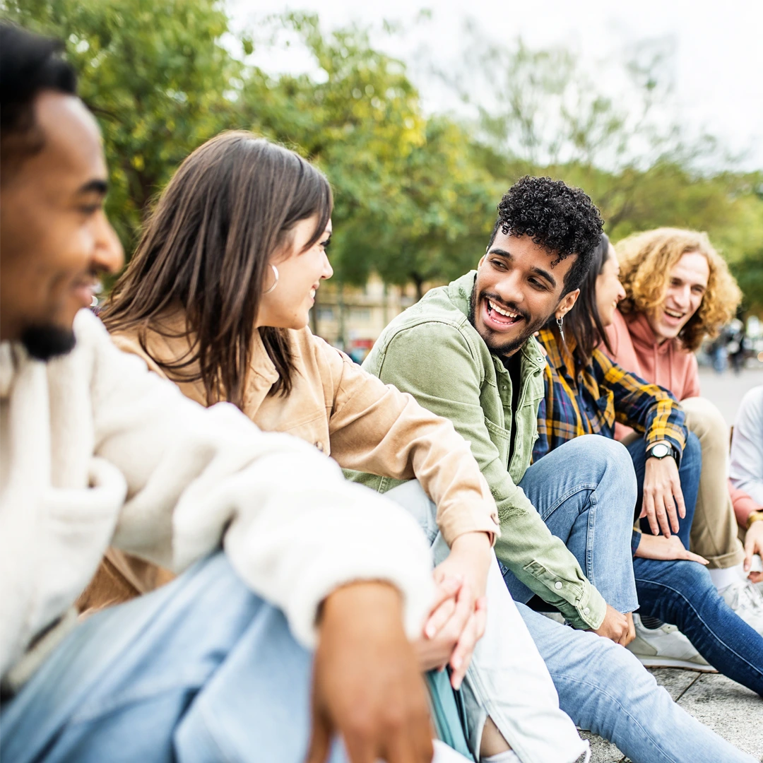 Young adults sitting outdoors, smiling and talking—peer support for whole-person inpatient rehab in Arizona at Changes Healing Center.