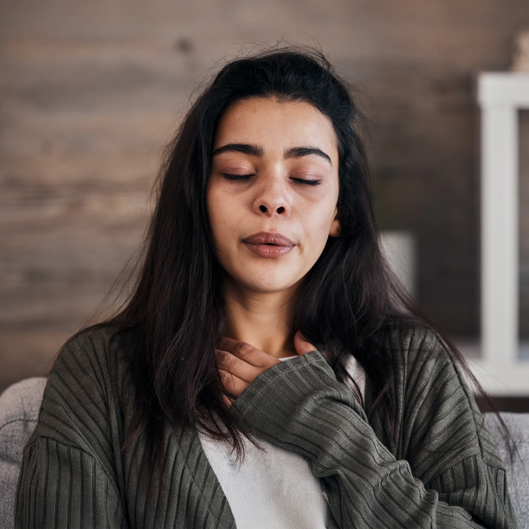 A-Closer-Look-at-Bipolar-Disorder-Treatment-Mobile Woman sitting with eyes closed and hand on chest, appearing calm and introspective, representing emotional self-awareness and healing.