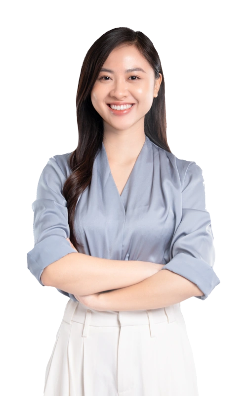 Smiling young woman standing confidently with arms crossed, wearing a light blue blouse and white pants, symbolizing trust, self-respect, and emotional healing in codependency recovery.
