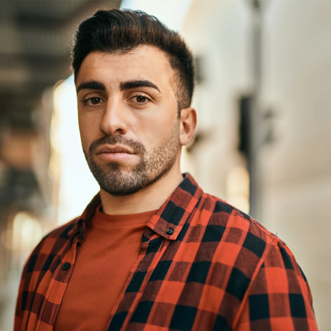 Serious young man in a red plaid shirt representing the challenges of Xanax addiction and the importance of seeking treatment in Arizona.