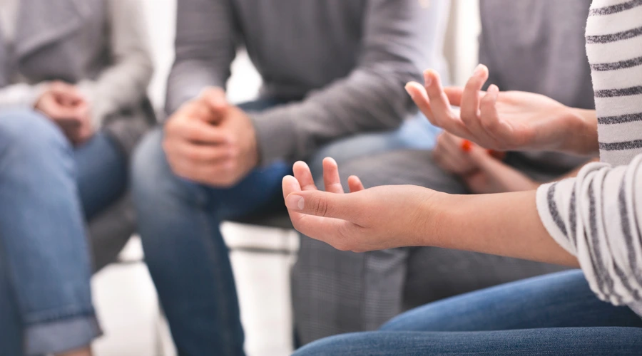 People participating in a supportive addiction recovery group therapy session, sharing openly in a safe environment.